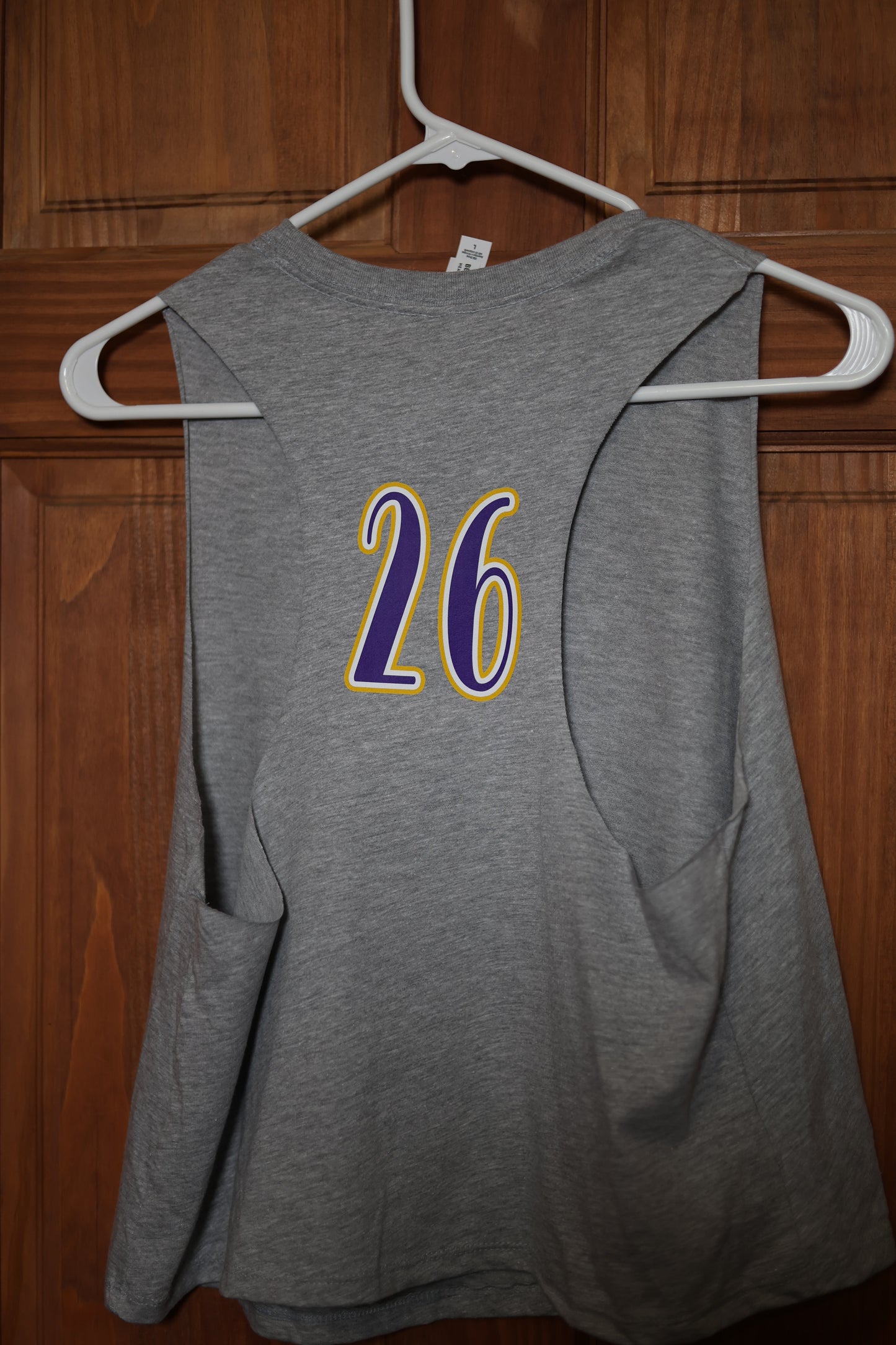 Back view of a heather gray muscle tank featuring a custom purple and gold player number 26 printed between the shoulder blades.