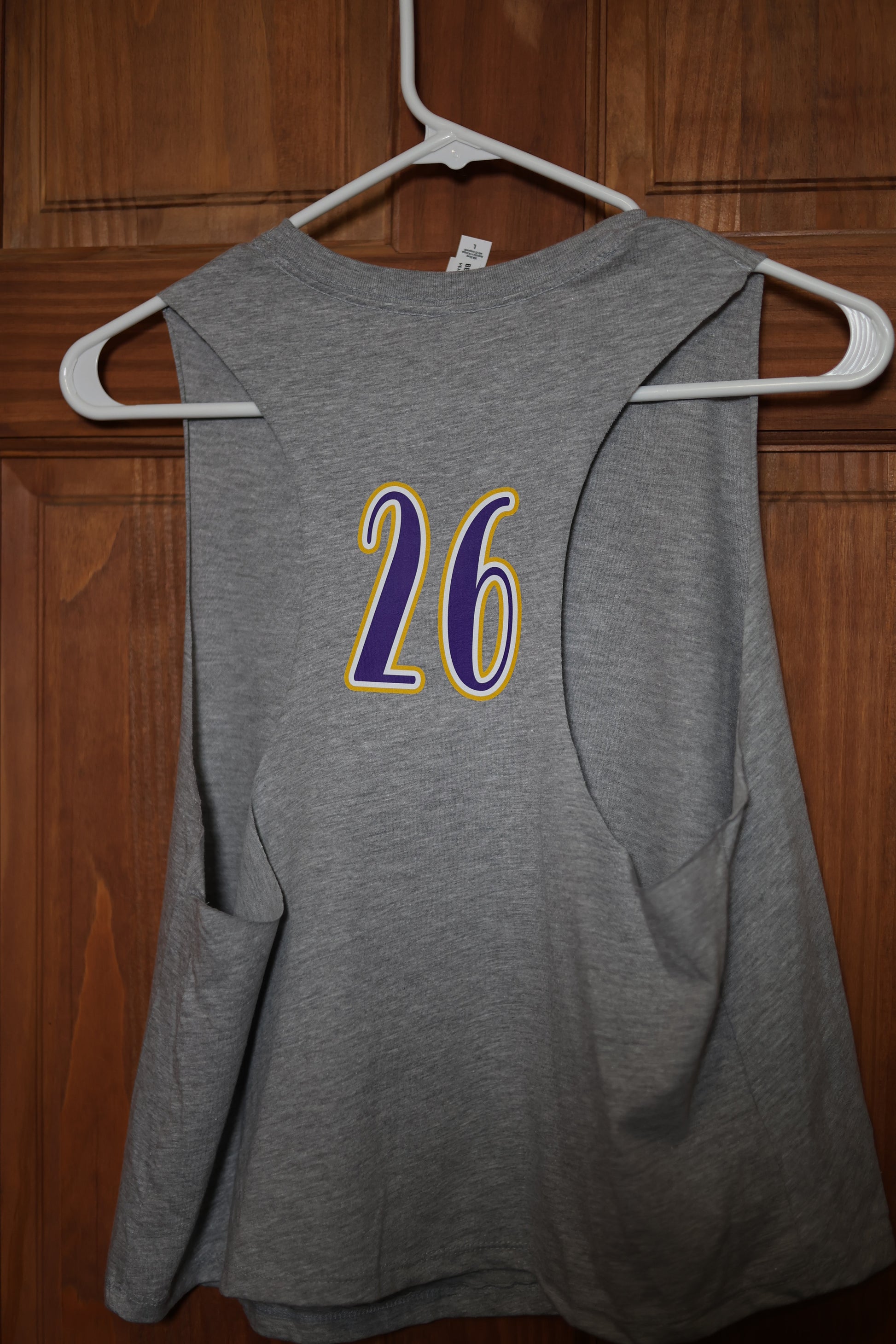 Back view of a heather gray muscle tank featuring a custom purple and gold player number 26 printed between the shoulder blades.