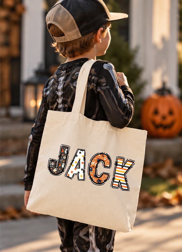 Boy holding canvas tote with Halloween letters